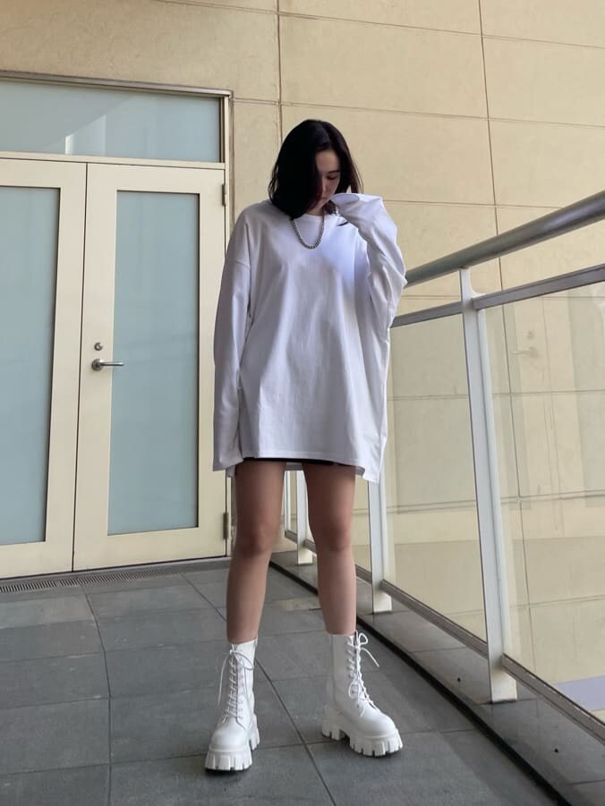 ホワイト系のTシャツ/カットソー、ホワイト系のブーツ、ブラック系のスカートを着用したレディースの春コーディネートの2枚目の写真
