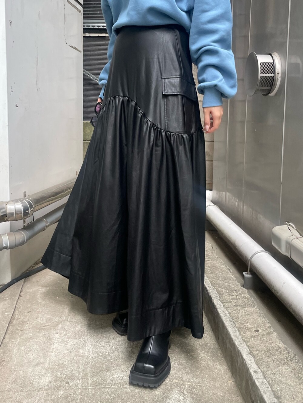 ブラック系のブーツ、ブラック系のスカート、ブルー系のスウェットを着用したレディースの秋コーディネートの4枚目の写真