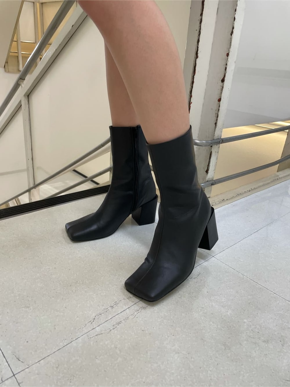 ブラック系のブーツ、ブルー系のワンピース、ブラック系のショルダーバッグを着用したレディースの秋コーディネートの7枚目の写真