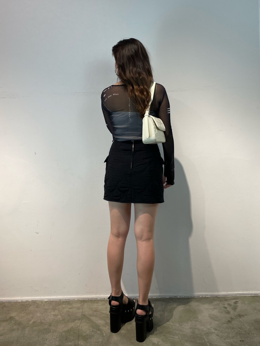 グレー系のTシャツ/カットソー、ブラック系のスカート、ブラック系のサンダルを着用したレディースの夏コーディネートの3枚目の写真