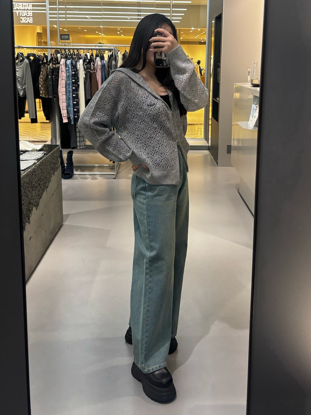 ブラック系のローファー、ベージュ系のデニムパンツ、グレー系のパーカーを着用したレディースの冬コーディネートの2枚目の写真