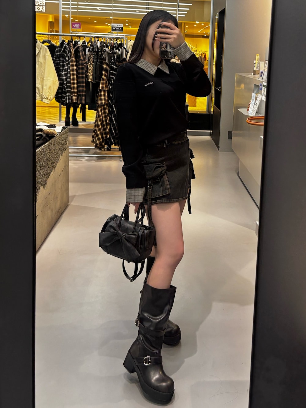 ブラック系のブーツ、ブルー系のその他パンツ、ブラック系のニット/セーターを着用したレディースの冬コーディネートの2枚目の写真