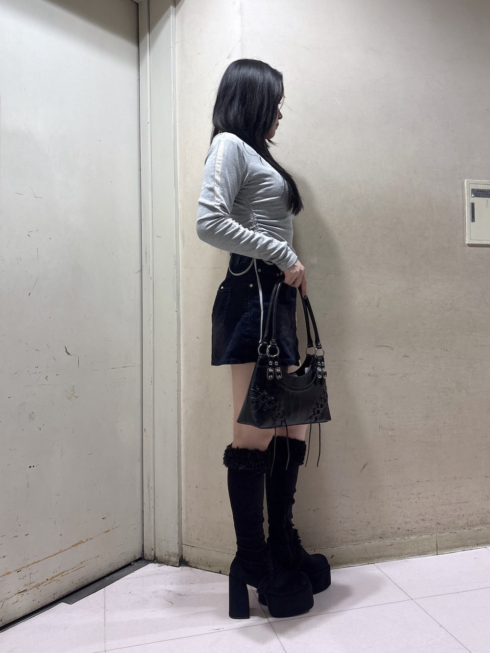 ブラック系のブーツ、ブラウン系のスカート、グレー系のTシャツ/カットソーを着用したレディースの秋コーディネートの2枚目の写真