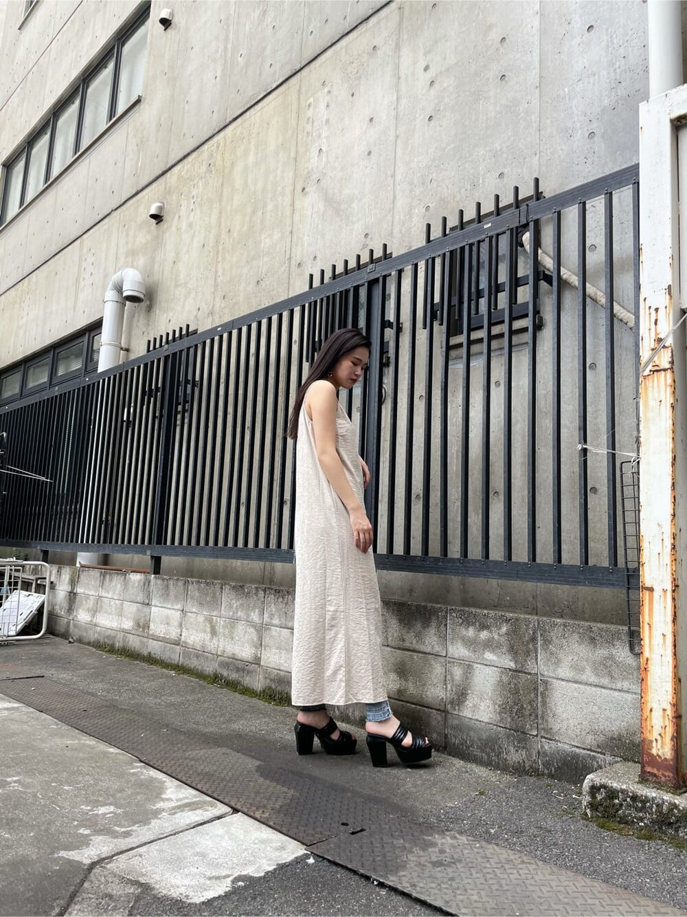 ブルー系のデニムパンツ、ホワイト系のワンピースを着用したレディースの夏コーディネートの2枚目の写真