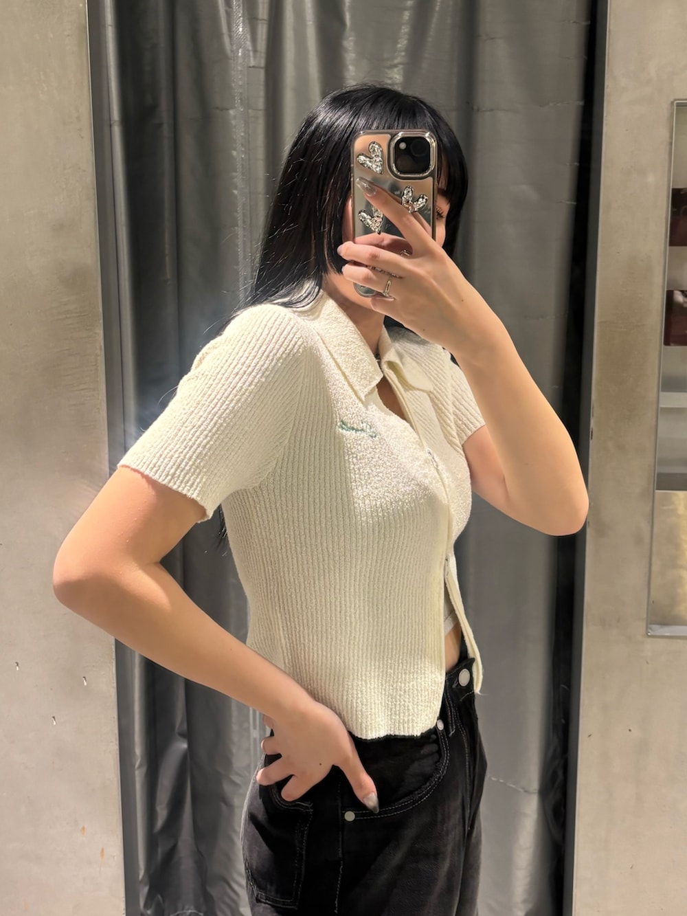 ホワイト系のニット/セーター、シルバー系のキャミソール、ブラック系のデニムパンツを着用したレディースの夏コーディネートの4枚目の写真