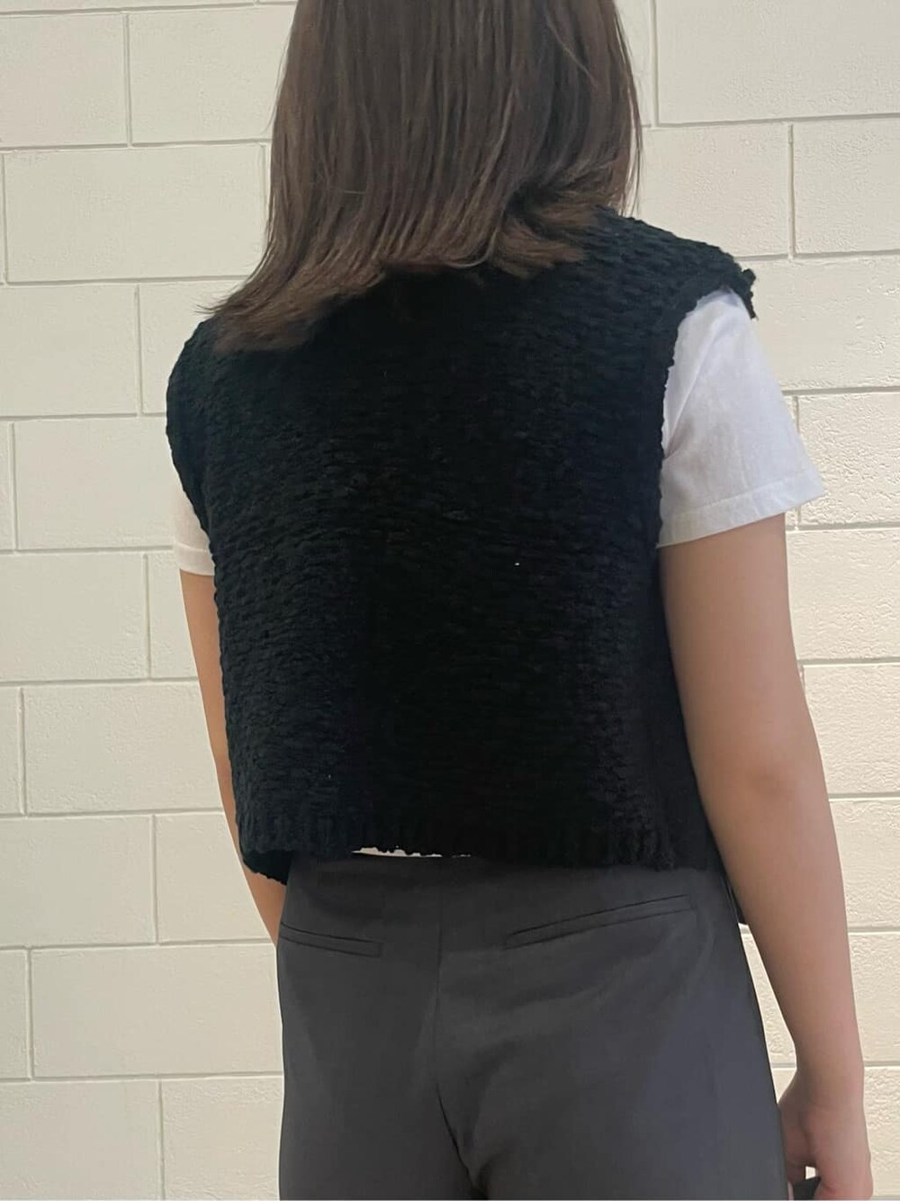 ブラック系のサンダル、ホワイト系のTシャツ/カットソー、ブラック系のベストを着用したレディースの夏コーディネートの6枚目の写真