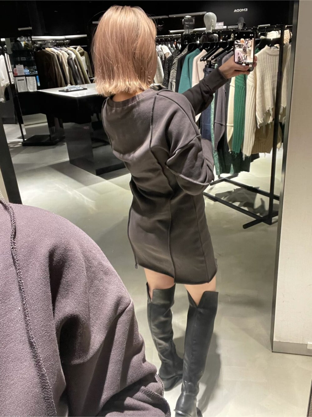 グレー系のワンピース、ブラック系のブーツを着用したレディースの秋コーディネートの4枚目の写真