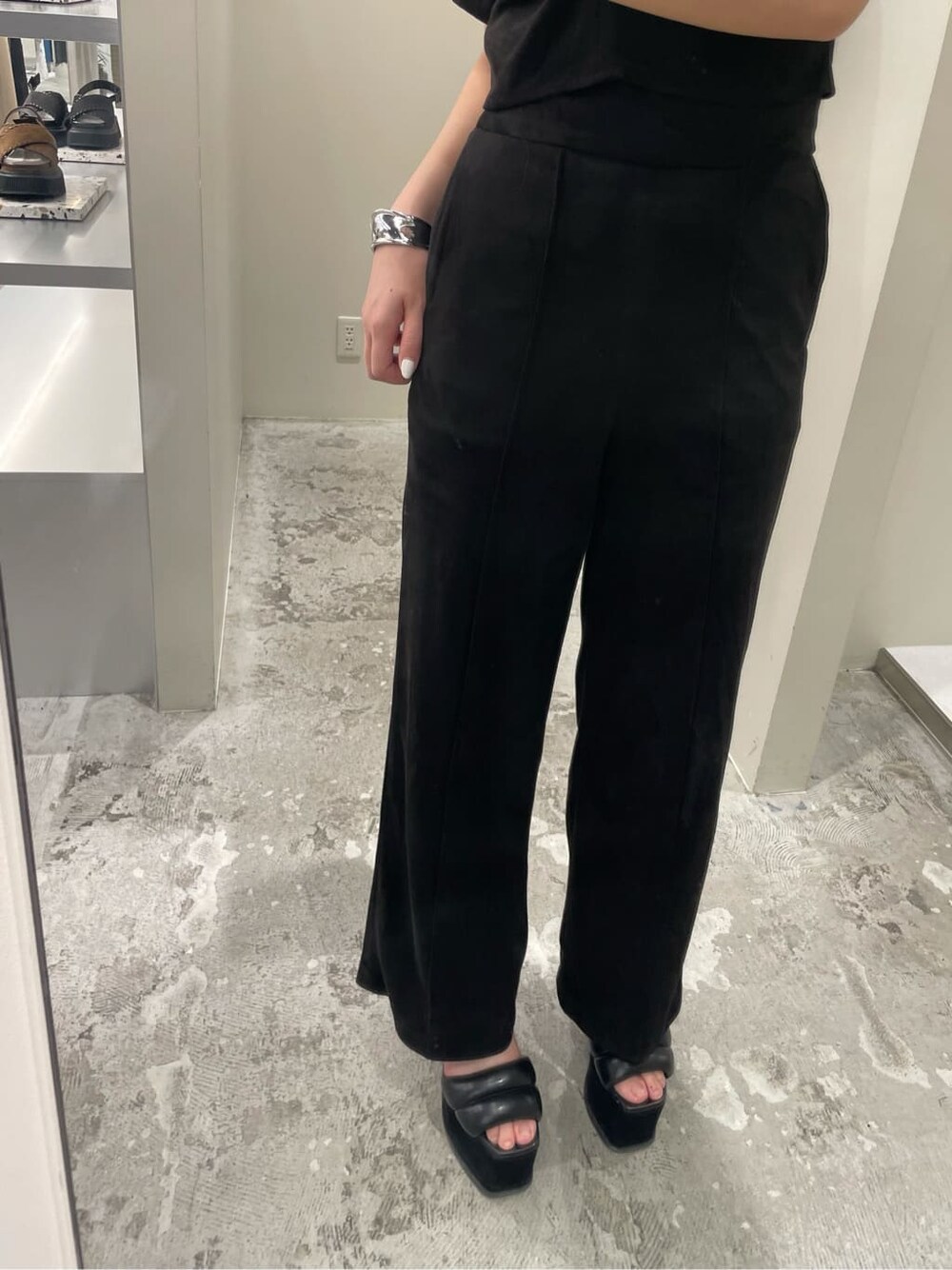 ブラウン系のハンドバッグ、ブラック系のその他パンツ、ブラック系のサンダルを着用したレディースの夏コーディネートの5枚目の写真