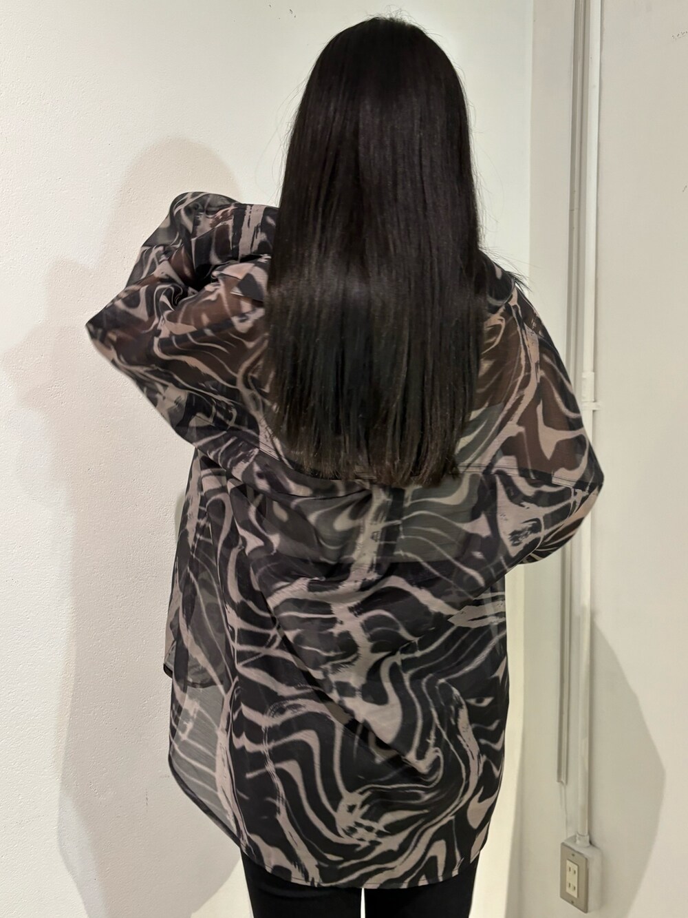 ブラック系のデニムパンツ、ベージュ系のシャツ/ブラウス、ブラック系のショルダーバッグを着用したレディースの春コーディネートの6枚目の写真