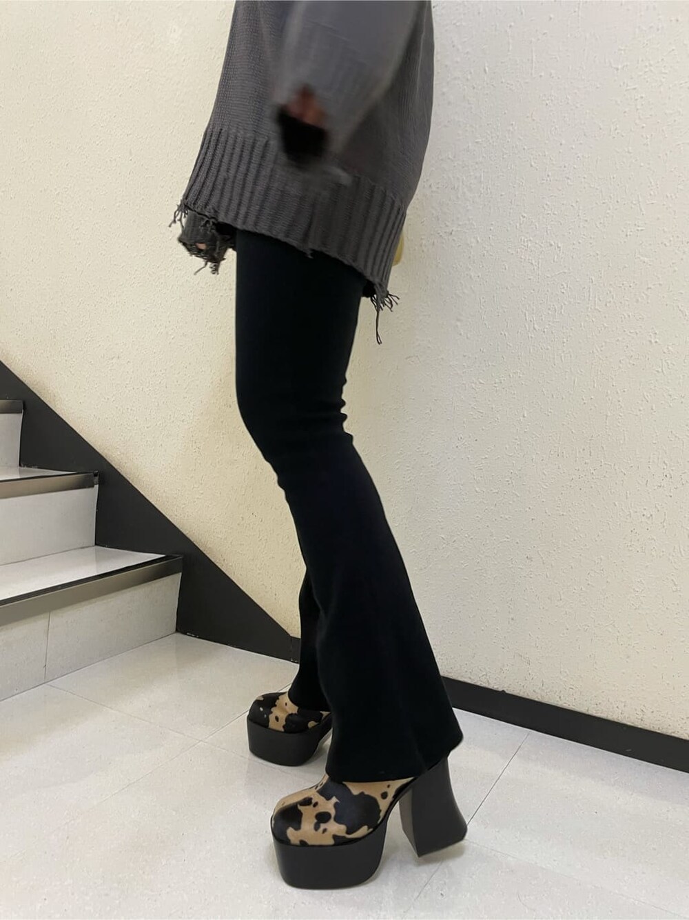 イエロー系のハンドバッグ、その他のブーツ、グレー系のニット/セーターを着用したレディースの秋コーディネートの5枚目の写真