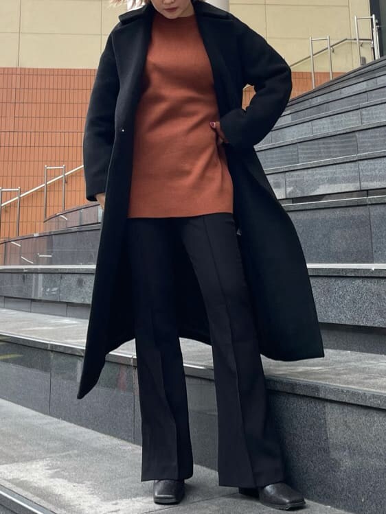 オレンジ系のニット/セーター、その他のブーツ、ブラック系のその他アウターを着用したレディースの秋コーディネートの2枚目の写真