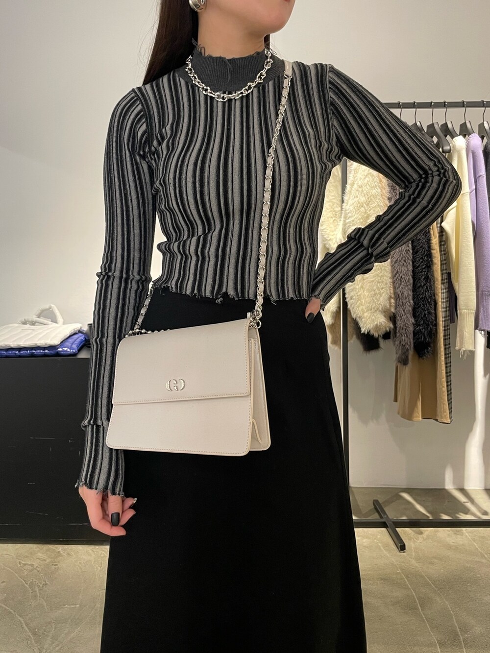 ブラック系のスカート、ブラック系のブーツ、その他のニット/セーターを着用したレディースの冬コーディネートの3枚目の写真