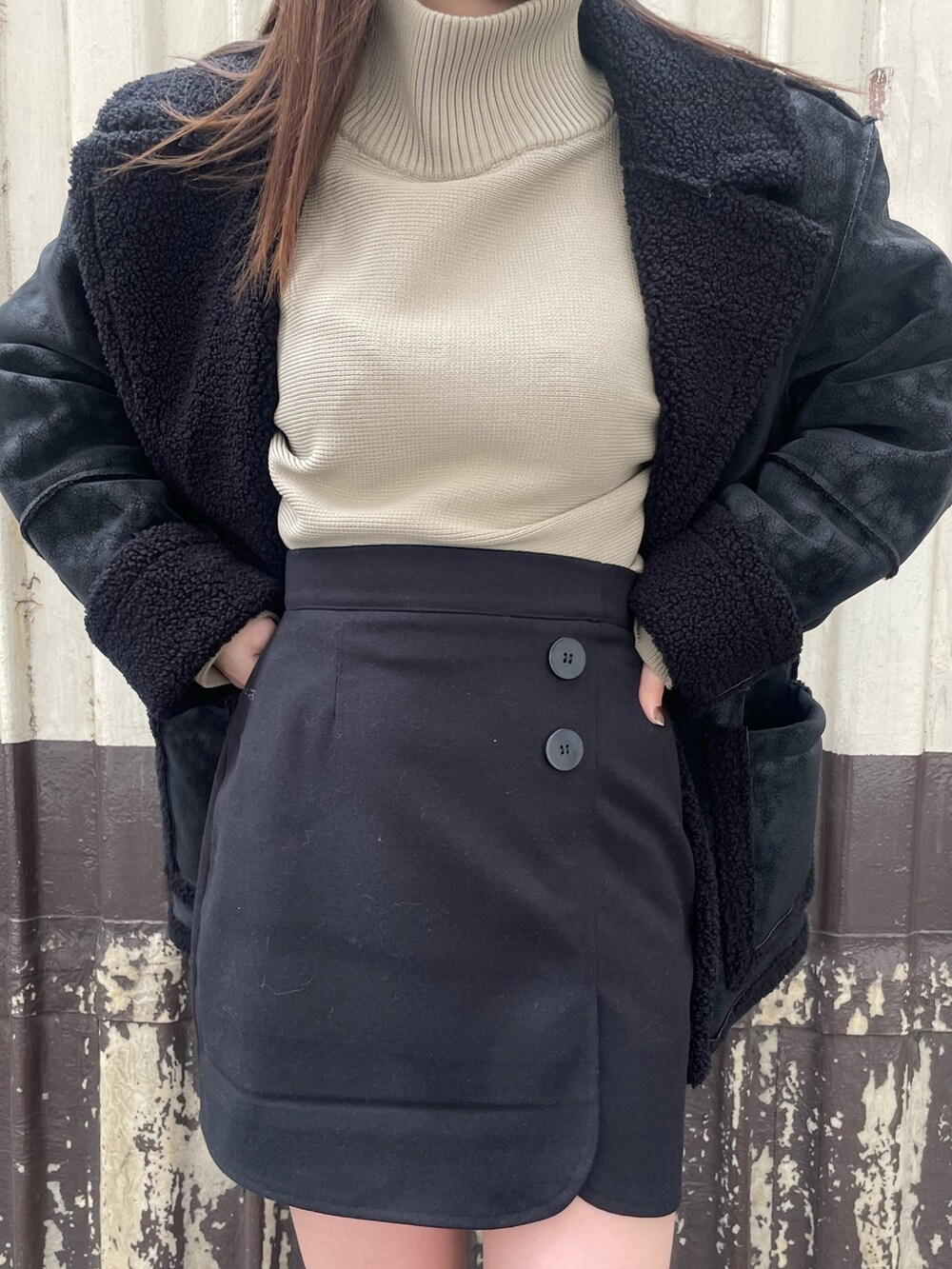 ブラック系のムートンコート、ブラック系のスカート、ホワイト系のブーツを着用したレディースの冬コーディネートの7枚目の写真