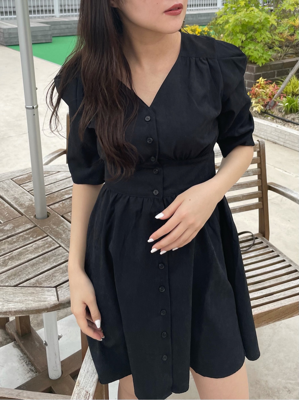 ブラック系のワンピース、ホワイト系のサンダル、ホワイト系のハットを着用したレディースの春コーディネートの3枚目の写真