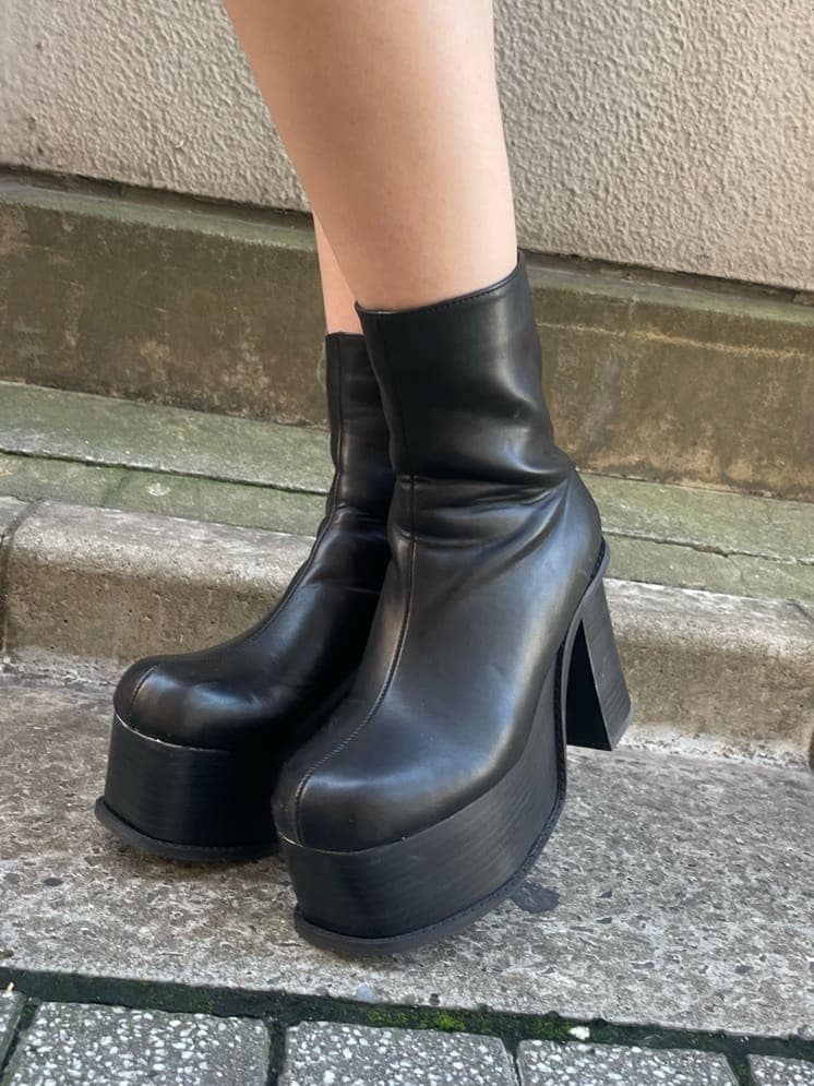 ブルー系のベスト、ブラック系のTシャツ/カットソー、ブラック系のブーツを着用したレディースの秋コーディネートの7枚目の写真