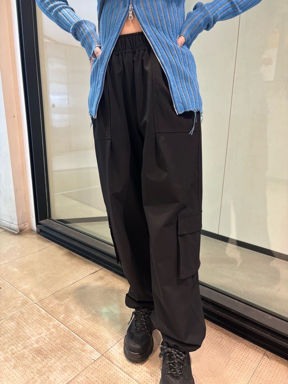 ブラック系のスニーカー、ブルー系のニット/セーター、ブラック系のその他パンツを着用したレディースの冬コーディネートの7枚目の写真