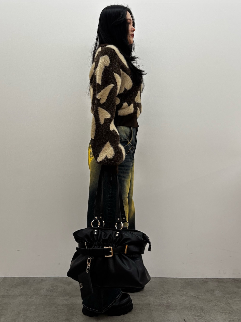 ブラウン系のブーツ、ブルー系のデニムパンツ、ブラウン系のニット/セーターを着用したレディースの冬コーディネートの2枚目の写真