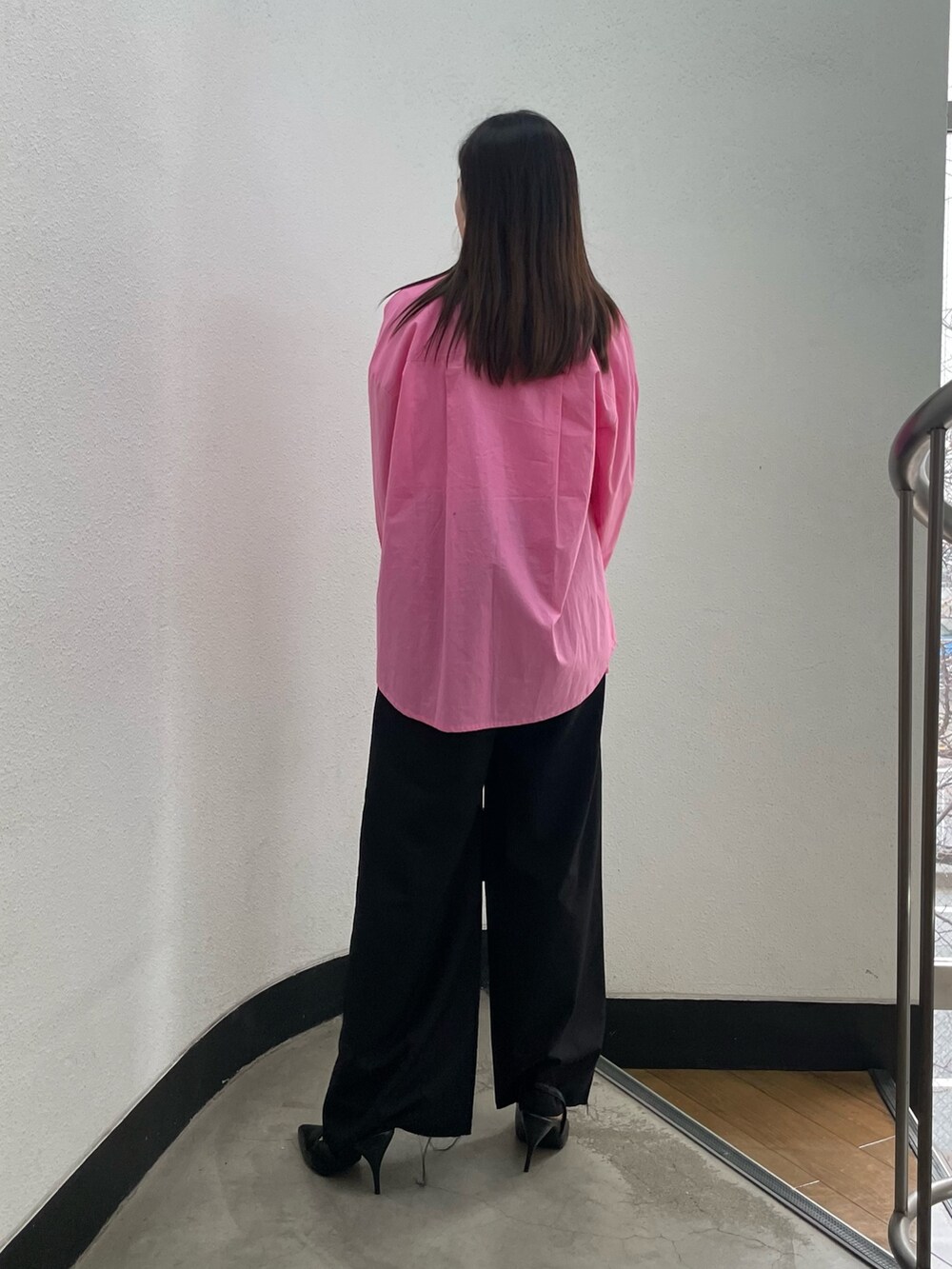 ブラック系のパンプス、ブラック系のハンドバッグ、ピンク系のシャツ/ブラウスを着用したレディースの冬コーディネートの3枚目の写真