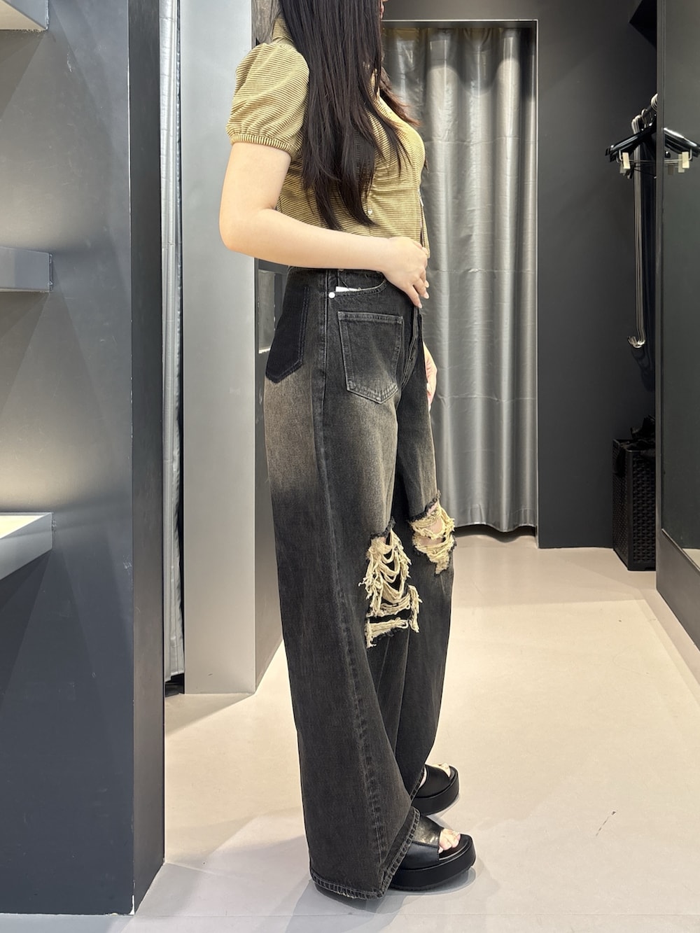 ブラック系のサンダル、ブラック系のデニムパンツ、ベージュ系のシャツ/ブラウスを着用したレディースの夏コーディネートの2枚目の写真