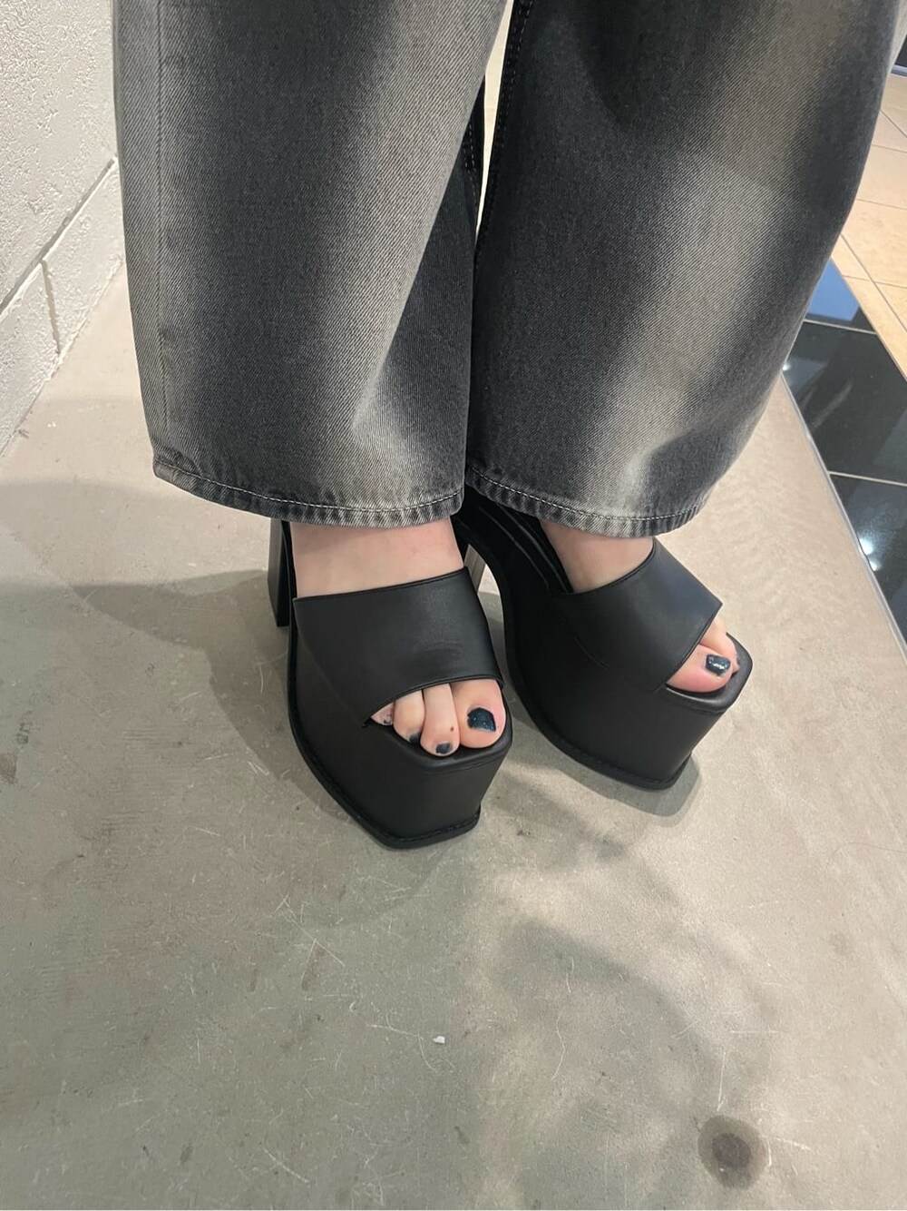 ブラック系のサンダル、ブラック系のタンクトップ、ブラック系のデニムパンツを着用したレディースの春コーディネートの8枚目の写真