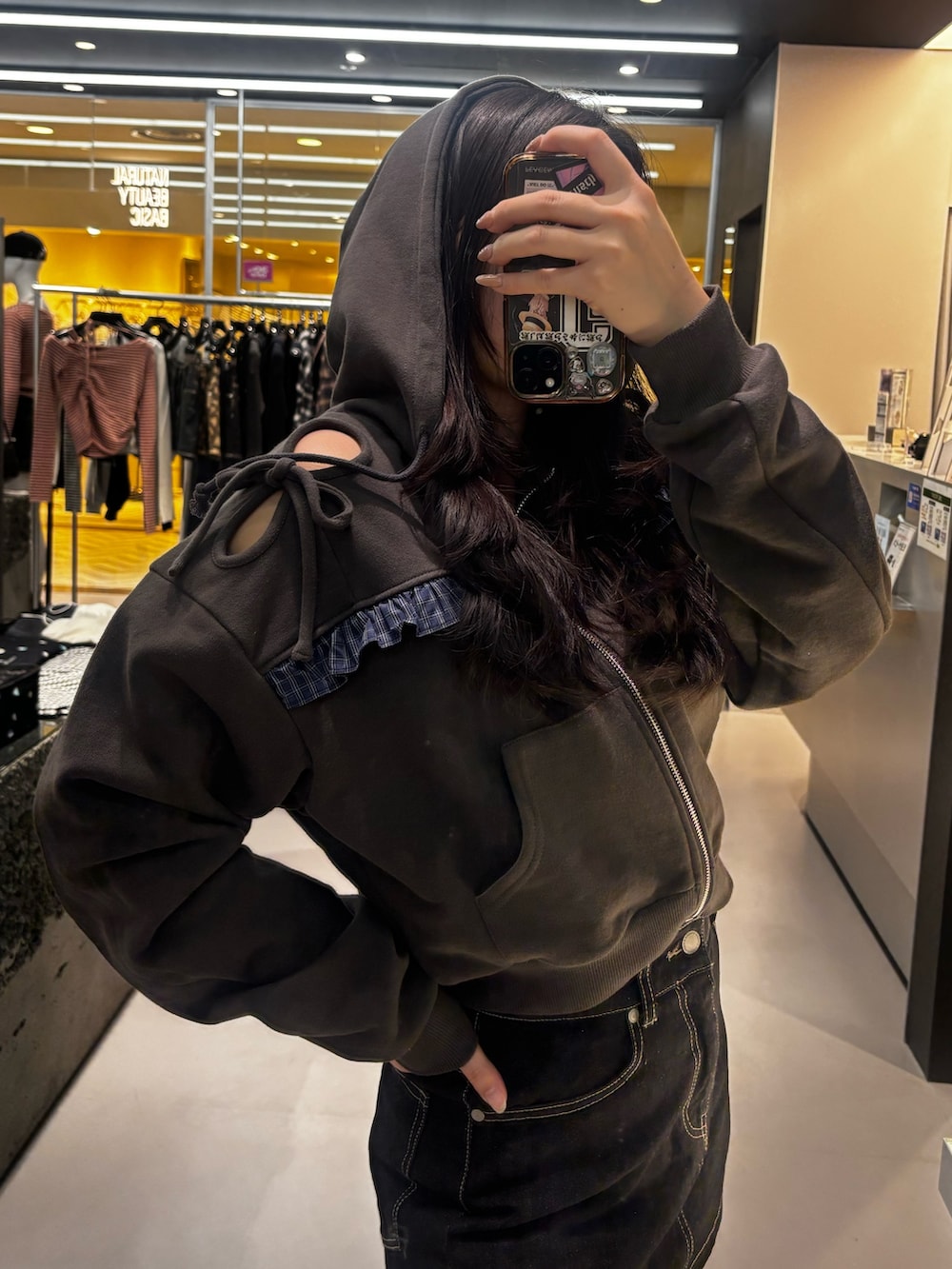 ブラック系のブーツ、ブラック系のパーカー、ブルー系のスカートを着用したレディースの冬コーディネートの4枚目の写真