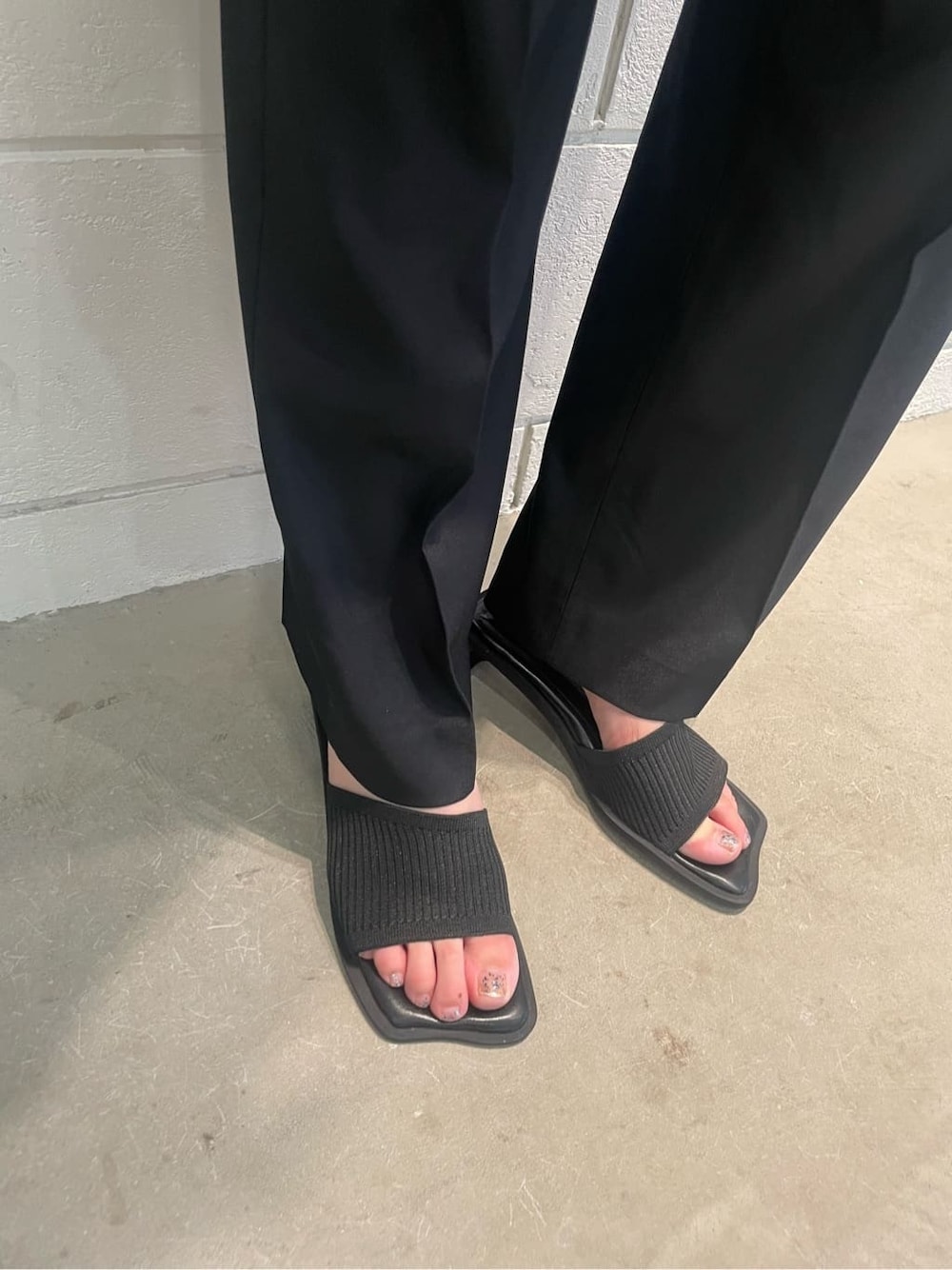 ブラック系のベスト、ブラック系のその他パンツ、ブラック系のサンダルを着用したレディースの夏コーディネートの6枚目の写真