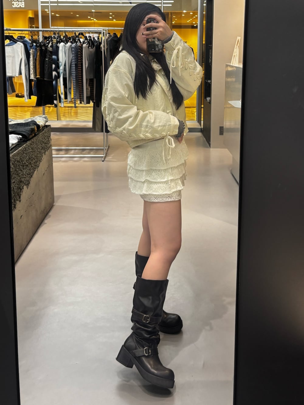 ブラック系のブーツ、グレー系のスカート、グレー系のニット/セーターを着用したレディースの春コーディネートの2枚目の写真