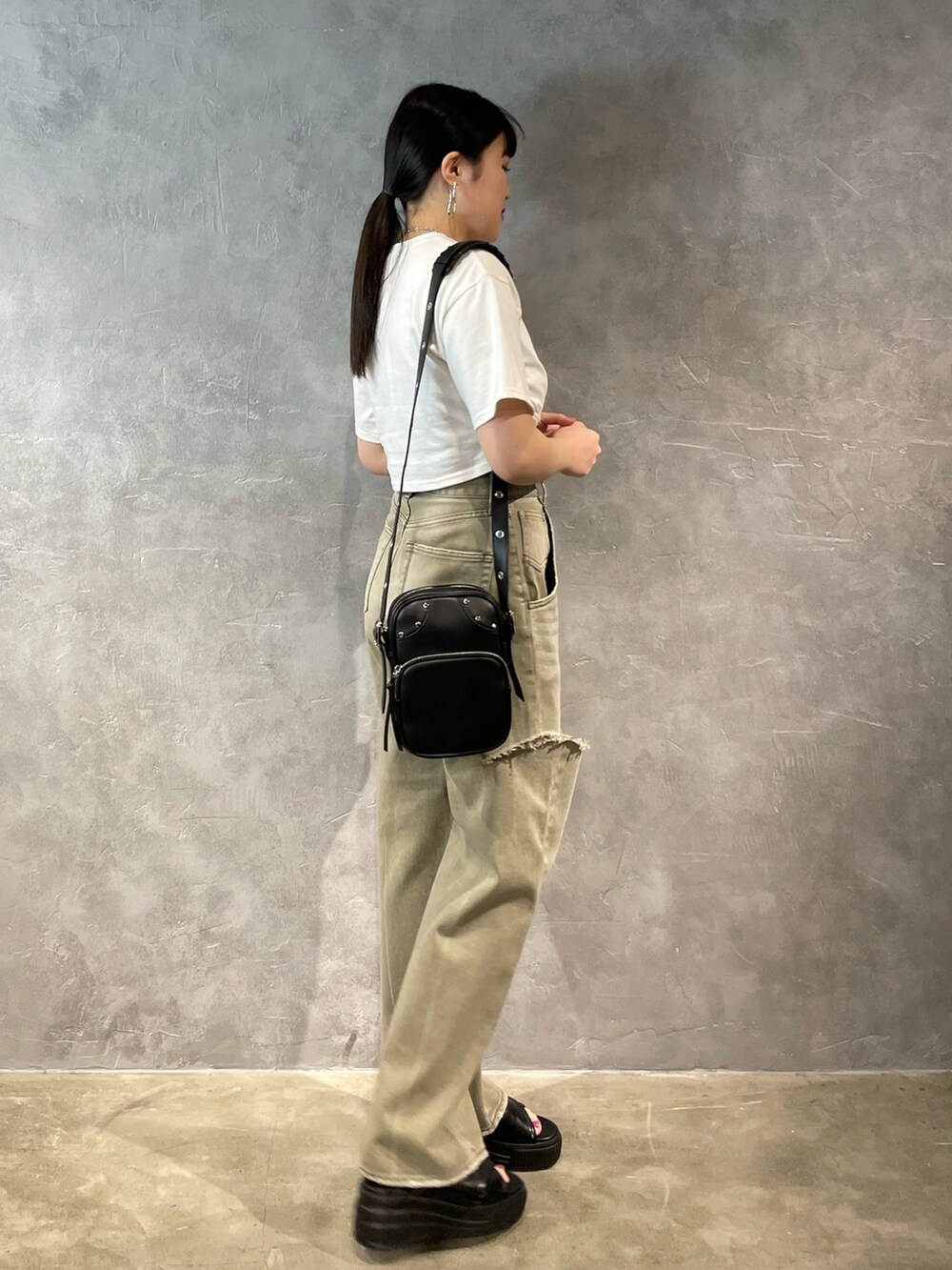 ベージュ系のデニムパンツ、グレー系のTシャツ/カットソー、ブラック系のショルダーバッグを着用したレディースの春コーディネートの2枚目の写真