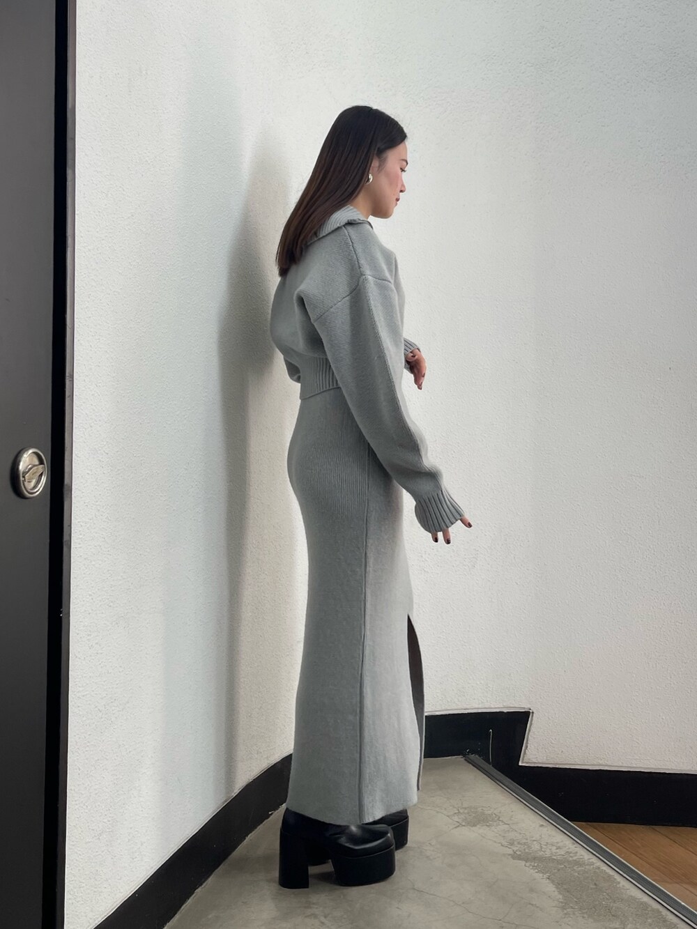 グレー系のニット/セーター、グレー系のスカート、ブラック系のブーツを着用したレディースの冬コーディネートの3枚目の写真