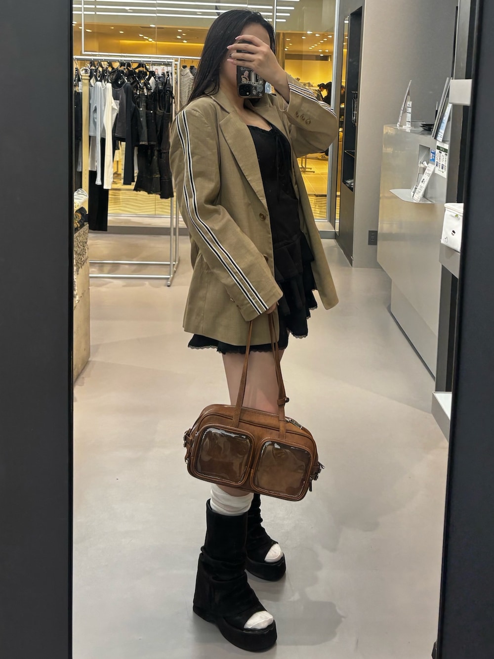 ブラック系のサンダル、グレー系のテーラードジャケット、ブラウン系のショルダーバッグを着用したレディースの春コーディネートの2枚目の写真