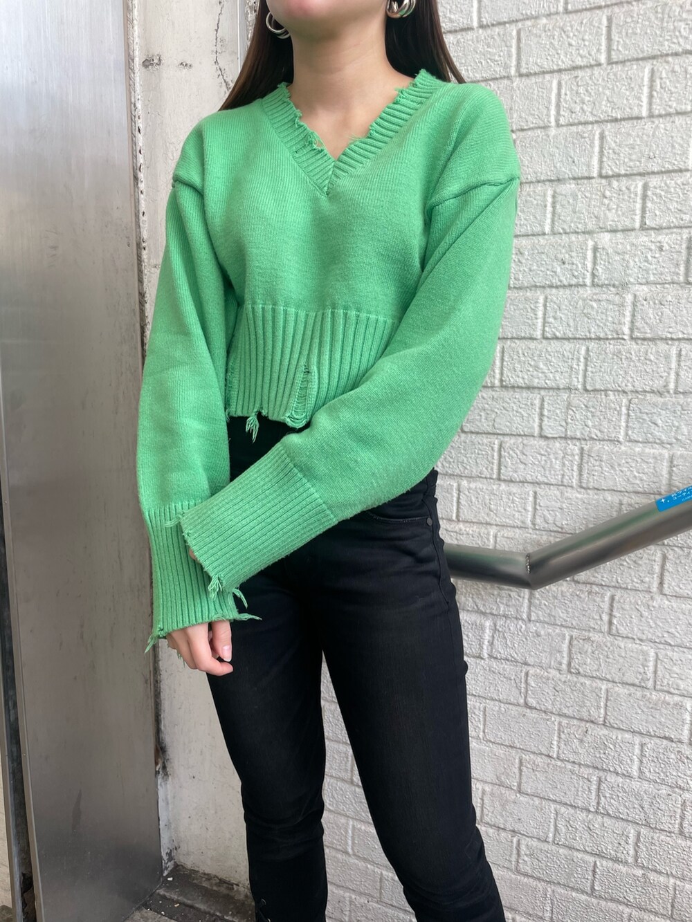 パープル系のチェスターコート、パープル系のニット/セーター、ブラック系のデニムパンツを着用したレディースの冬コーディネートの5枚目の写真