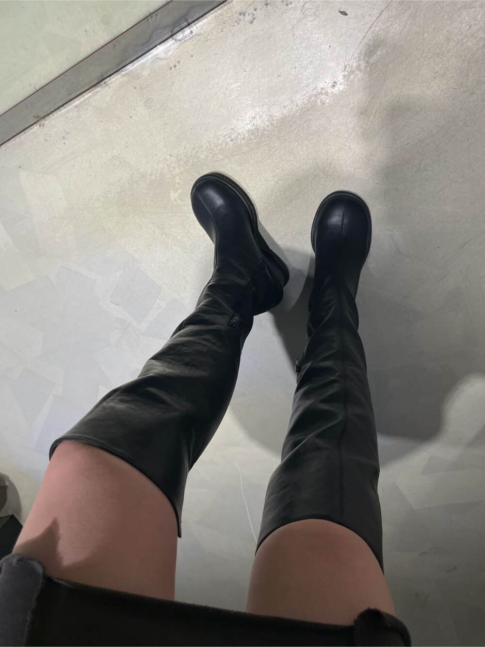 グレー系のワンピース、ブラック系のブーツを着用したレディースの秋コーディネートの5枚目の写真