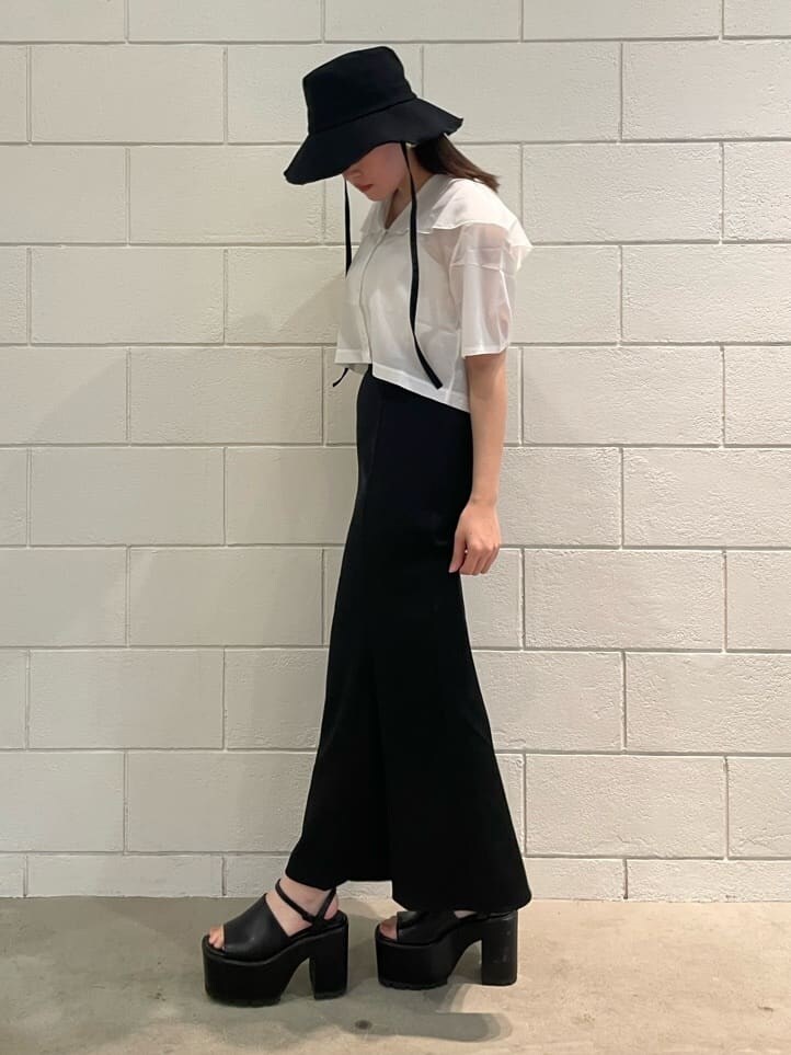 ホワイト系のシャツ/ブラウス、ブラック系のスカート、ブラック系のサンダルを着用したレディースの夏コーディネートの2枚目の写真