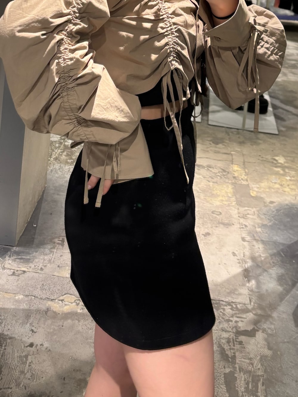 ブラック系のブーツ、ブラック系のスカート、ベージュ系のシャツ/ブラウスを着用したレディースの春コーディネートの6枚目の写真