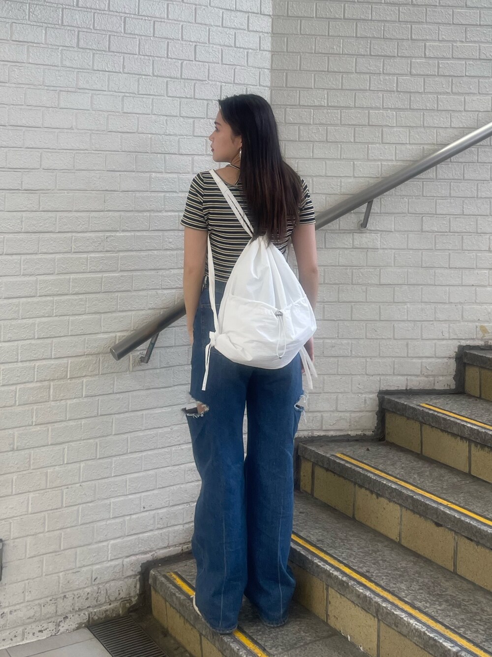 ブラック系のデニムパンツ、その他のTシャツ/カットソー、ホワイト系のバックパック/リュックを着用したレディースの夏コーディネートの3枚目の写真