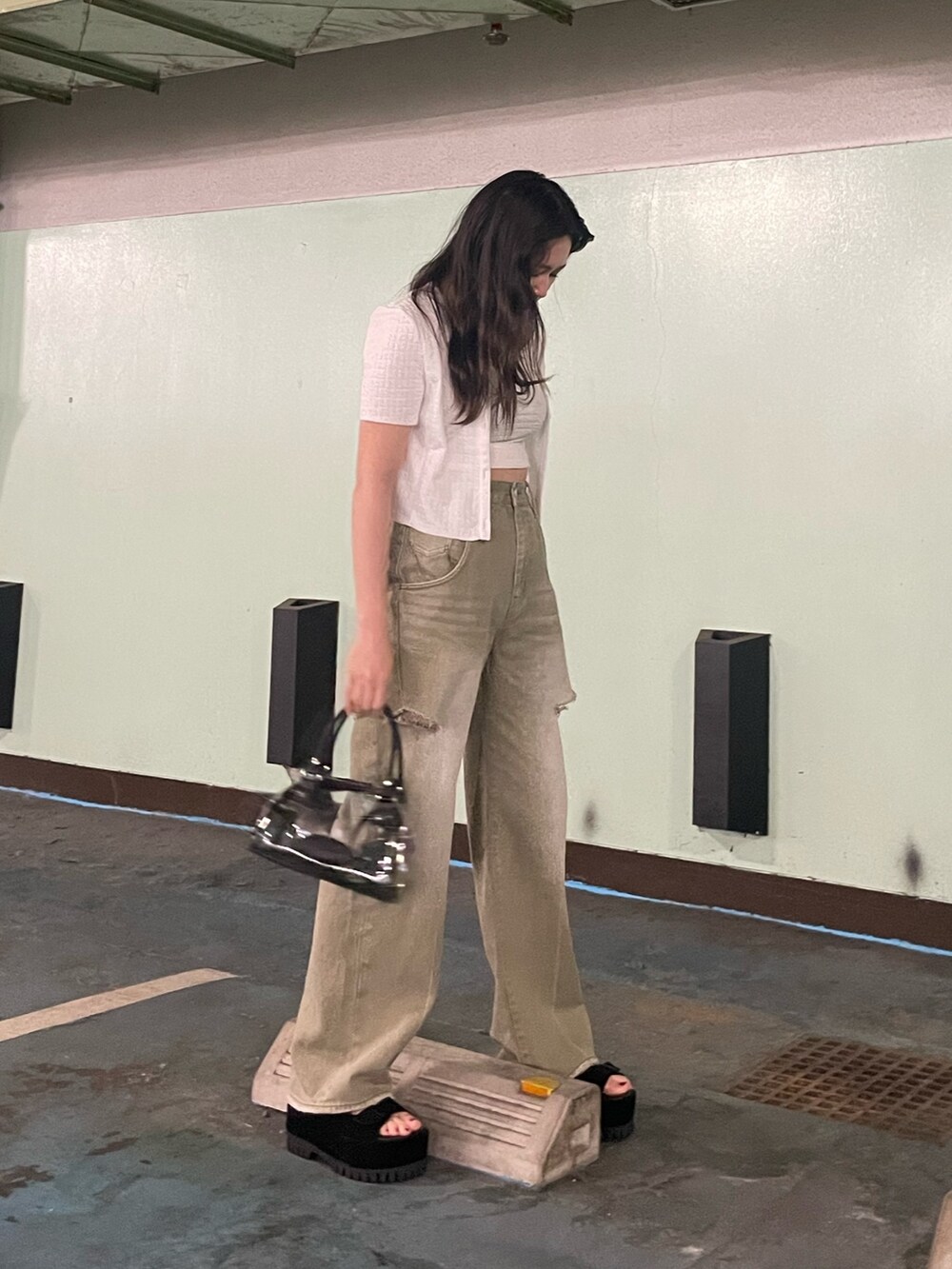 ブラック系のデニムパンツ、その他のハンドバッグ、ホワイト系のアンサンブルを着用したレディースの夏コーディネートの2枚目の写真