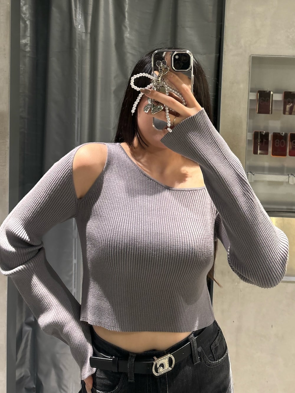 ブルー系のデニムパンツ、グレー系のニット/セーター、ブラック系のブーツを着用したレディースの秋コーディネートの3枚目の写真