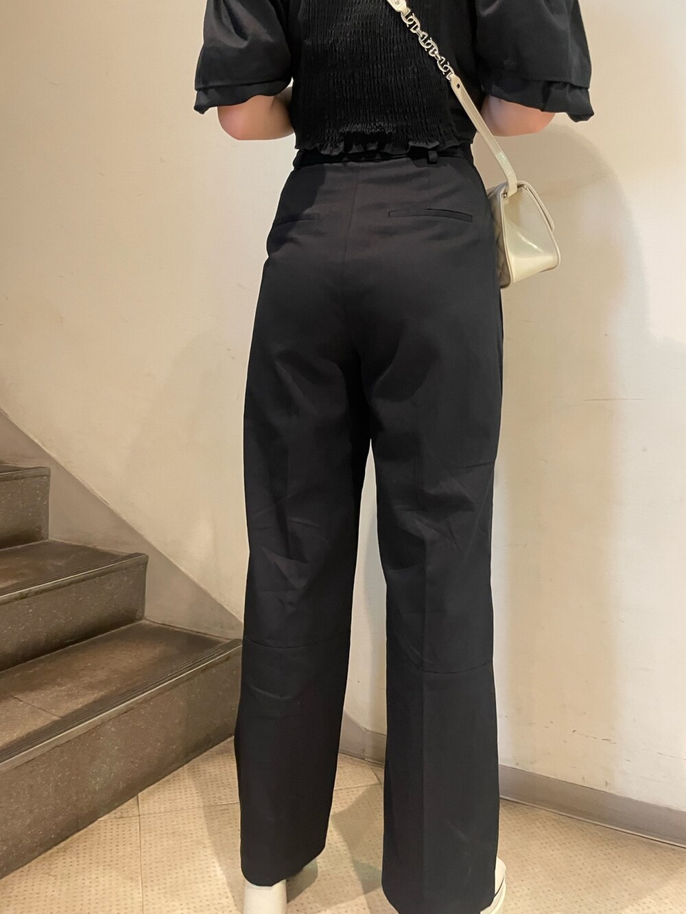 ブラック系のシャツ/ブラウス、ブラック系のその他パンツ、ホワイト系のサンダルを着用したレディースの春コーディネートの9枚目の写真