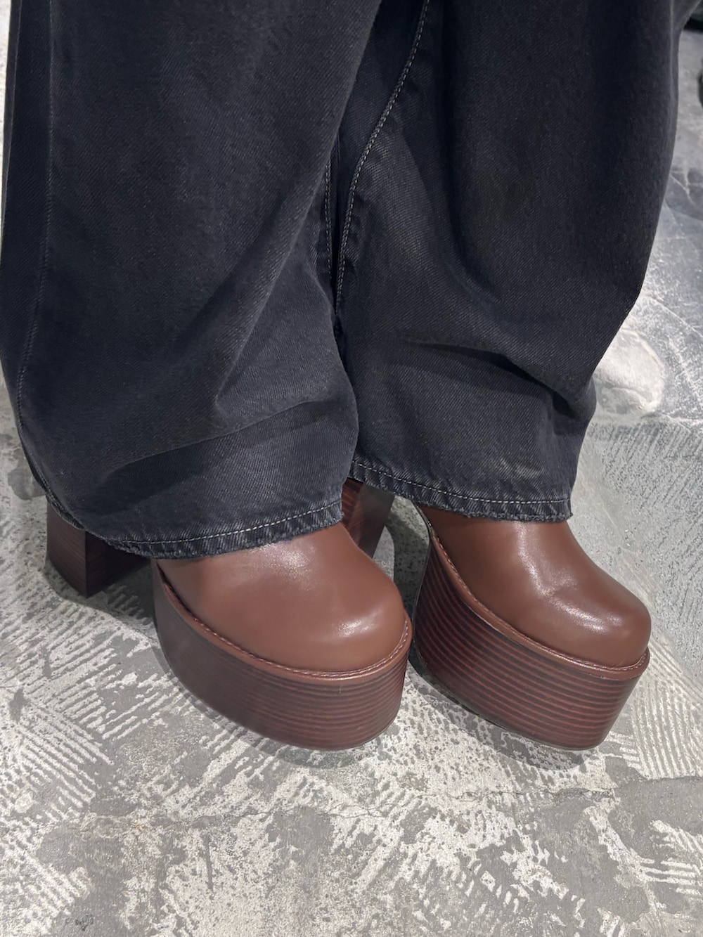 ブラック系のデニムパンツ、ブラック系のブーツ、ホワイト系のシャツ/ブラウスを着用したレディースの秋コーディネートの8枚目の写真