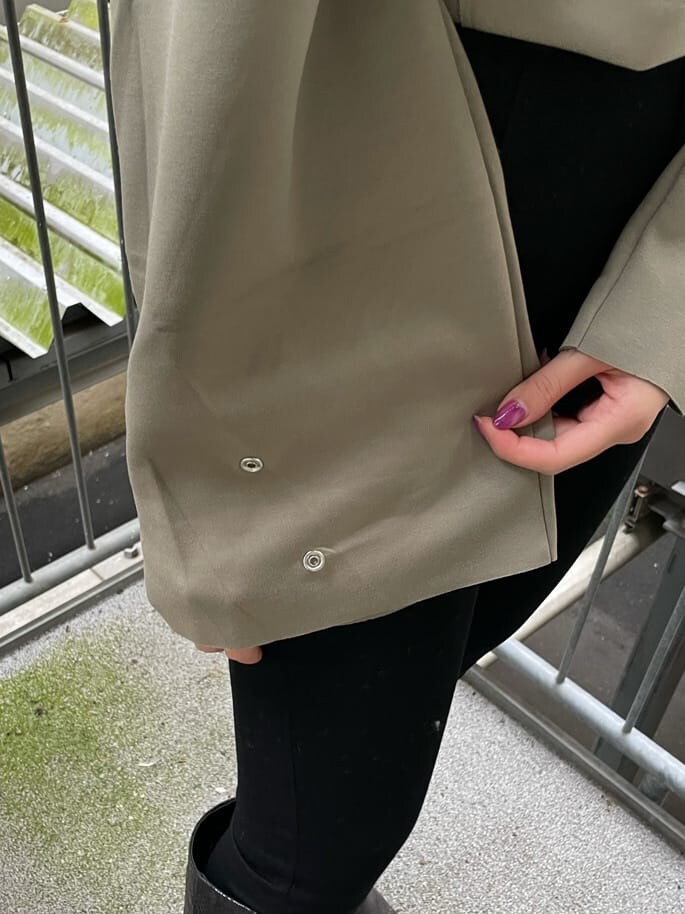 ブラック系のデニムパンツ、ホワイト系のトレンチコート、その他のブーツを着用したレディースの秋コーディネートの4枚目の写真