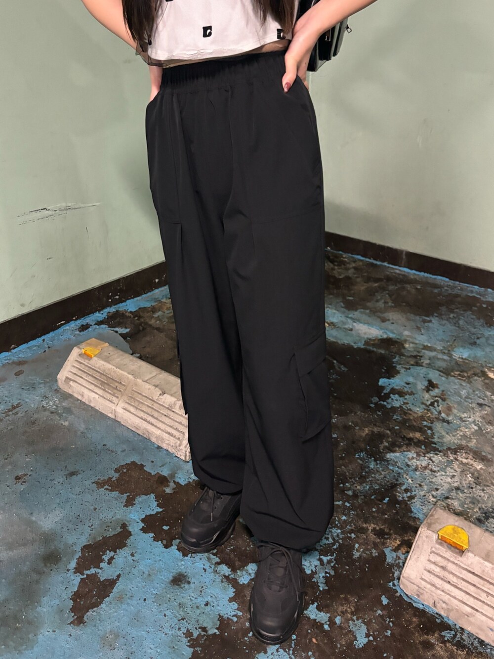 ブラック系のスニーカー、ホワイト系のTシャツ/カットソー、ブラック系のその他パンツを着用したレディースの春コーディネートの6枚目の写真