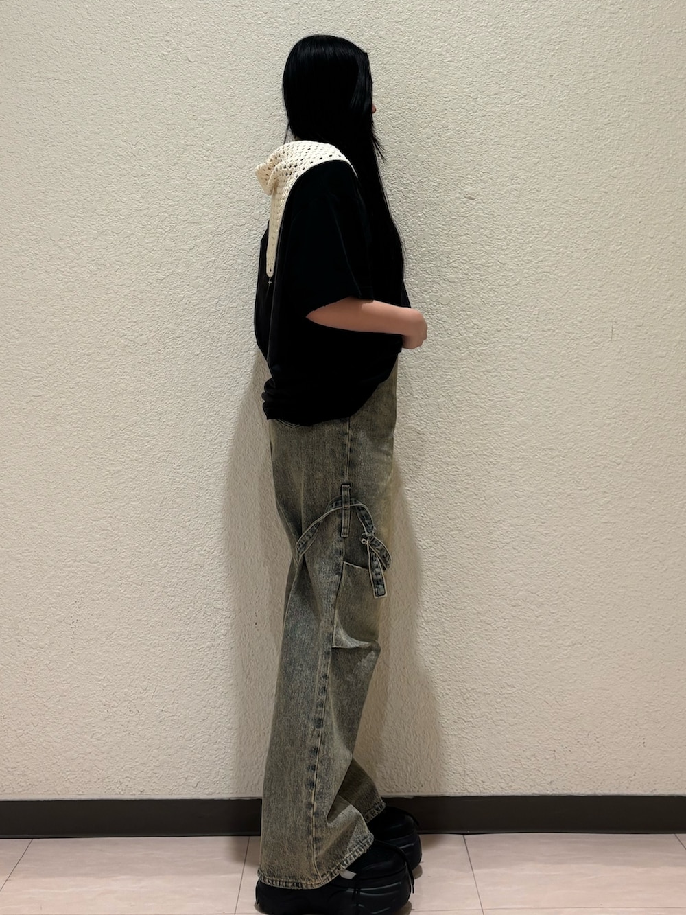 ブラック系のスニーカー、ベージュ系のデニムパンツ、ブラック系のTシャツ/カットソーを着用したレディースの春コーディネートの2枚目の写真