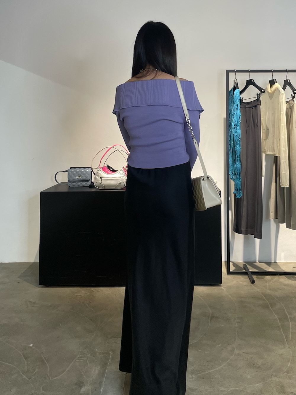 ブラック系のスカート、ブラック系のブーツ、パープル系のニット/セーターを着用したレディースの春コーディネートの3枚目の写真