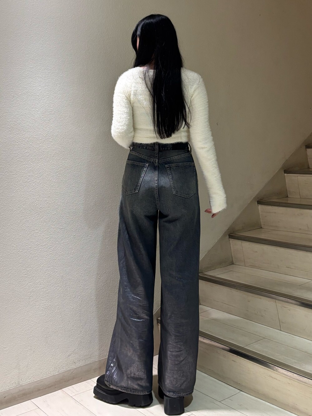 ホワイト系のニット/セーター、ブルー系のデニムパンツ、ブラック系のブーツを着用したレディースの秋コーディネートの3枚目の写真