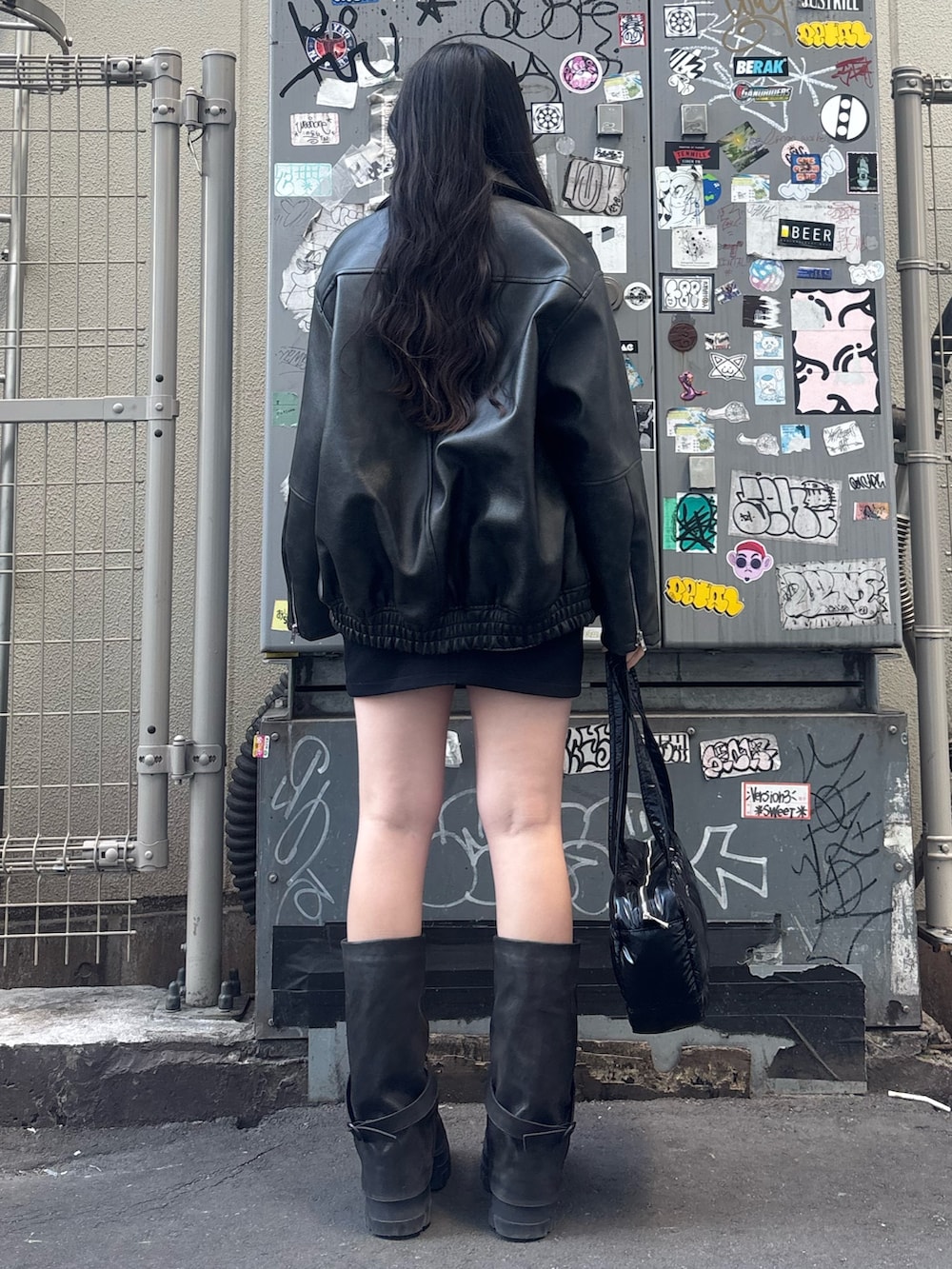 ブラック系のブーツ、ブラック系のスカート、ブラック系のブルゾンを着用したレディースの冬コーディネートの3枚目の写真