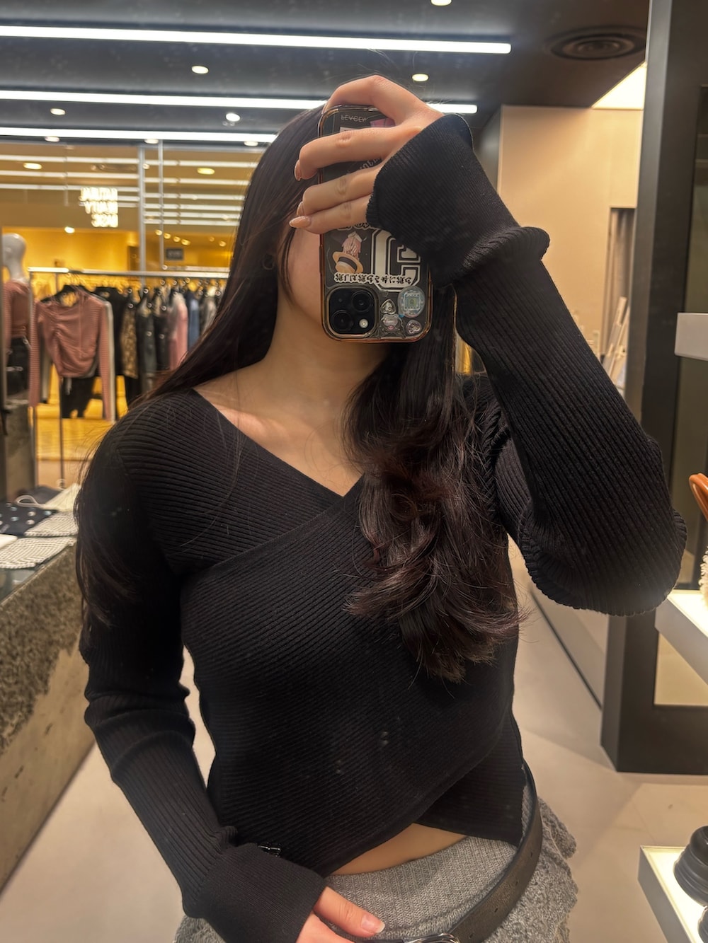 ブラック系のブーツ、グレー系のスカート、ブラック系のニット/セーターを着用したレディースの冬コーディネートの3枚目の写真