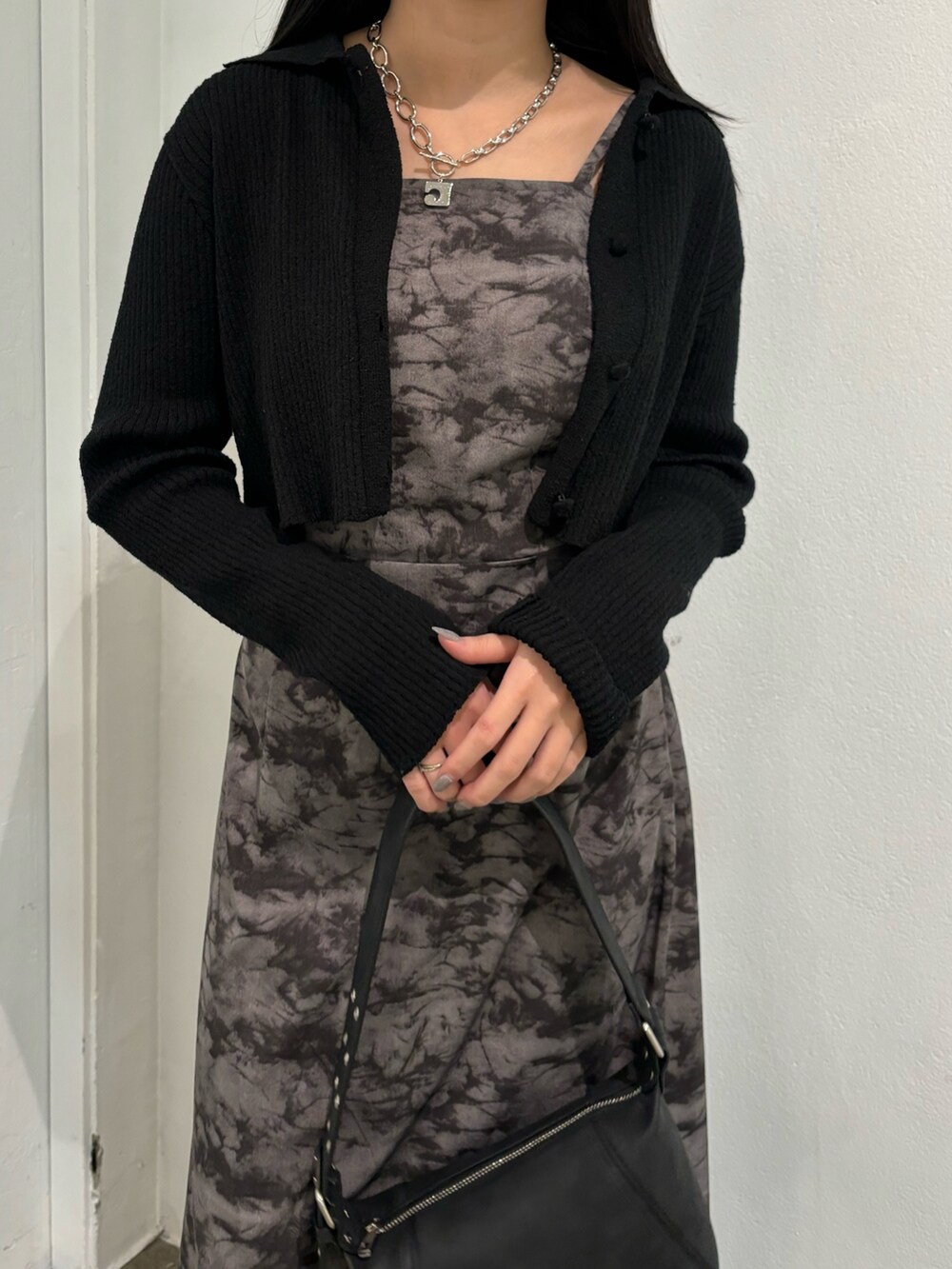 ブラック系のニット/セーター、ブラック系のショルダーバッグを着用したレディースの春コーディネートの4枚目の写真