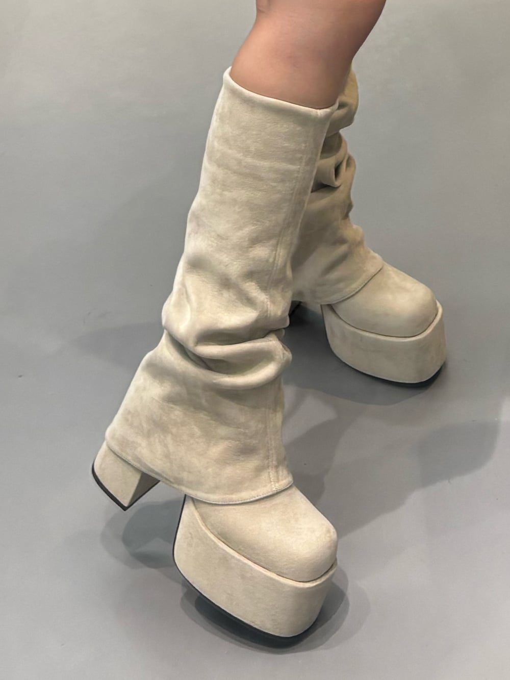 ホワイト系のブーツ、ホワイト系のニット/セーター、ブラック系のスカートを着用したレディースの秋コーディネートの4枚目の写真