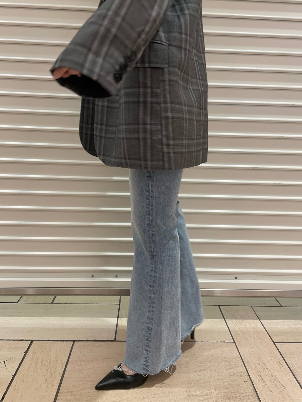 ブラック系のテーラードジャケット、ブルー系のニット/セーター、ブルー系のデニムパンツを着用したレディースの春コーディネートの8枚目の写真