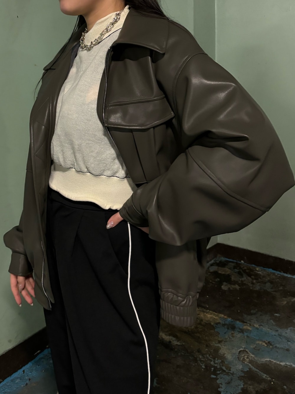 ブラック系のスラックス、ブラック系のローファー、グレー系のブルゾンを着用したレディースの冬コーディネートの5枚目の写真